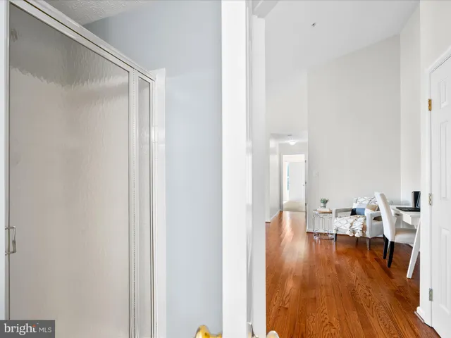 a view of a hallway with wooden floor table and chairs