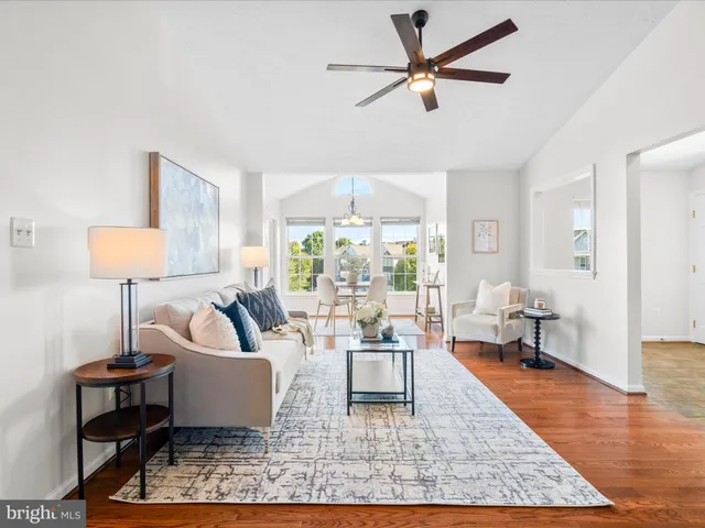 a living room with furniture a lamp a rug and a large window
