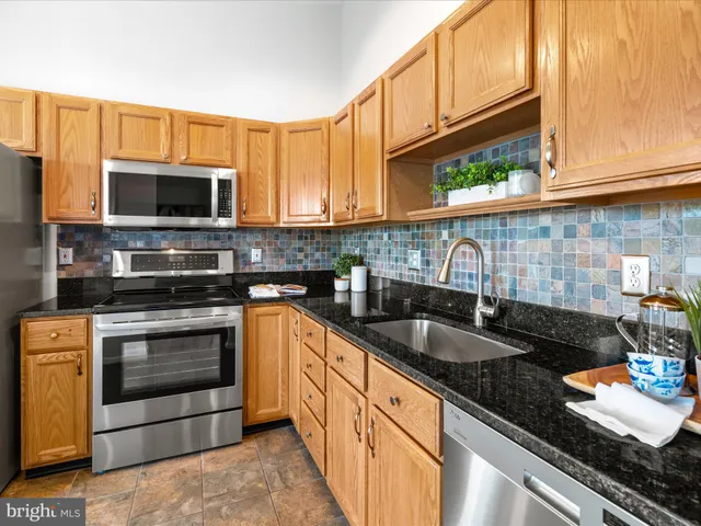 a kitchen with granite countertop a sink a stove and cabinets