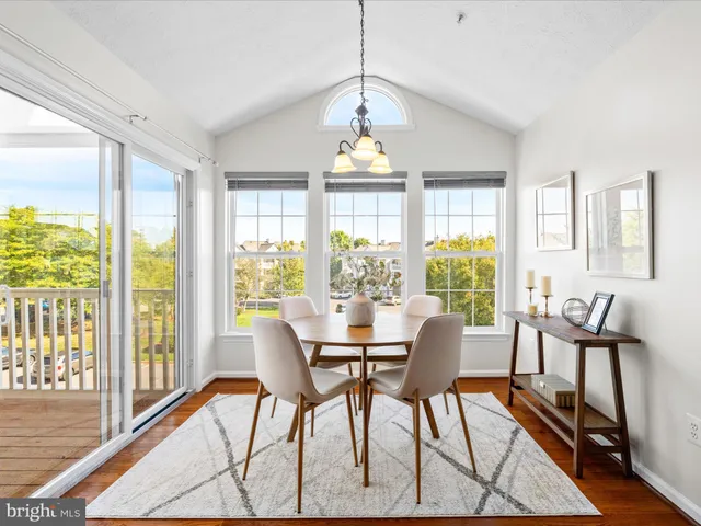 a dining room with furniture a chandelier and wooden floor