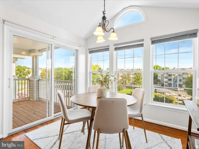a view of a dining room with furniture a chandelier and wooden floor