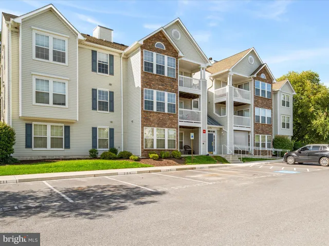 a front view of a building with street and trees