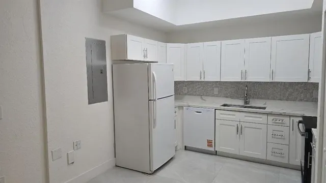 a kitchen with white cabinets and white appliances