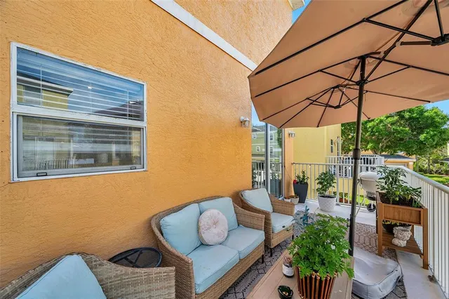 a patio with glass top table and chairs