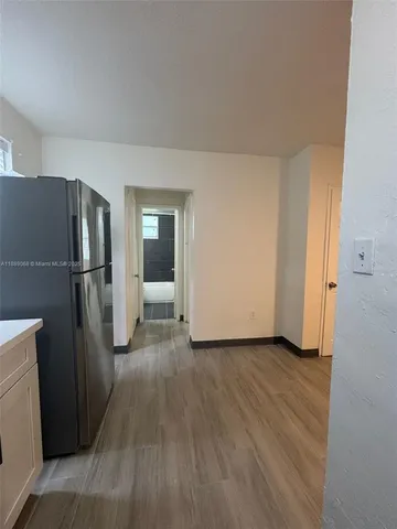 a view of a refrigerator in kitchen and wooden floor