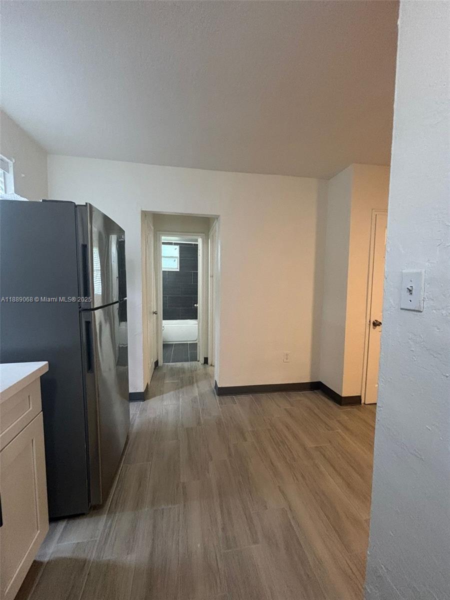 708 Northwest 4th Avenue, Unit 4 Miami, FL 33136 - Photo 11 of 17 a view of a refrigerator in kitchen and wooden floor