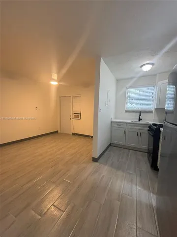 a view of a kitchen with a sink dishwasher cabinets and wooden floor