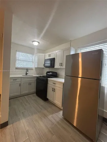 a kitchen with a refrigerator sink and cabinets