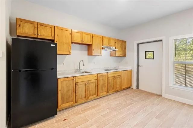 a kitchen with granite countertop stainless steel appliances a refrigerator a sink and cabinets