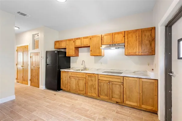 a kitchen with stainless steel appliances granite countertop a refrigerator and a sink
