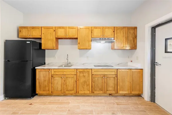 a kitchen with a refrigerator and cabinets