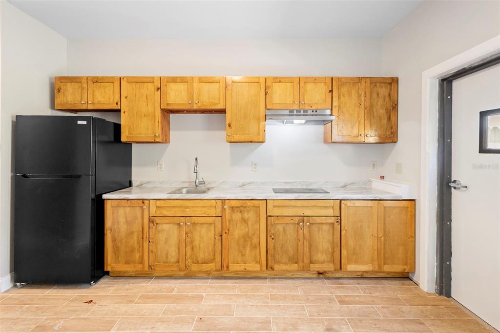 4460 North Fort Christmas Road, Unit 3 Christmas, FL 32820 - Photo 5 of 15 a kitchen with a refrigerator and cabinets