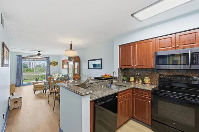 a kitchen with granite countertop a stove sink and cabinets