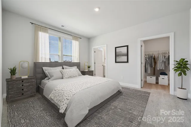 a bedroom with a large bed and potted plant