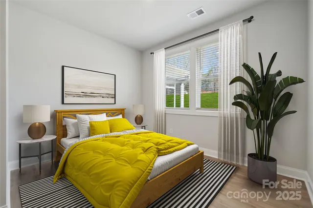 a bedroom that has a bed and a potted plant