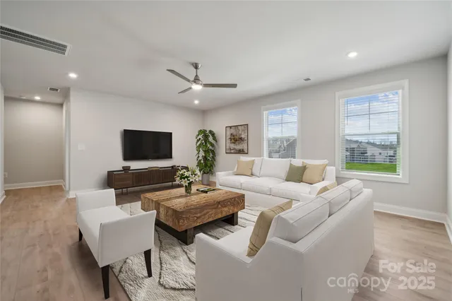 a living room with furniture a large window and a flat screen tv