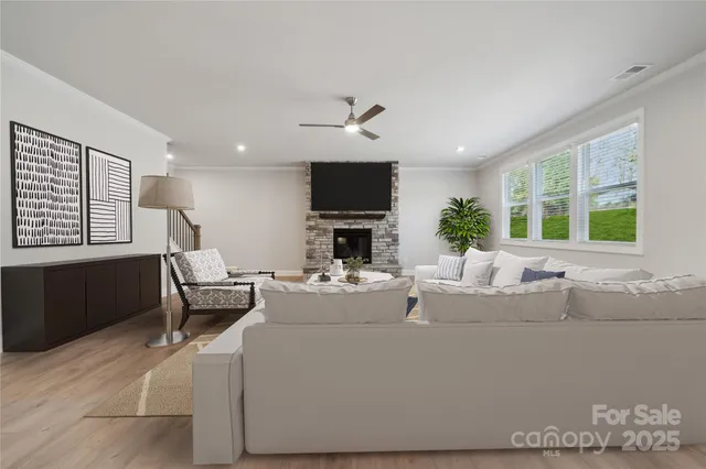 a living room with furniture a flat screen tv and a fireplace