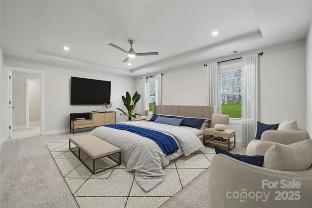 a spacious bedroom with a large bed and a flat screen tv