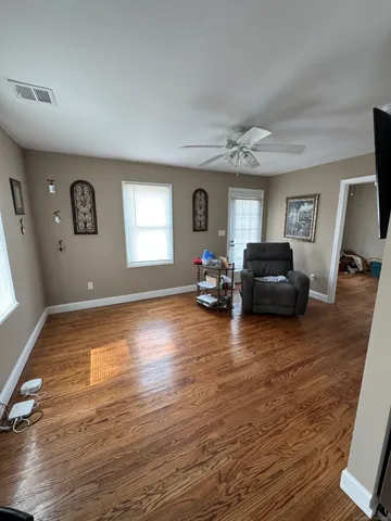 a living room with furniture and a wooden floor