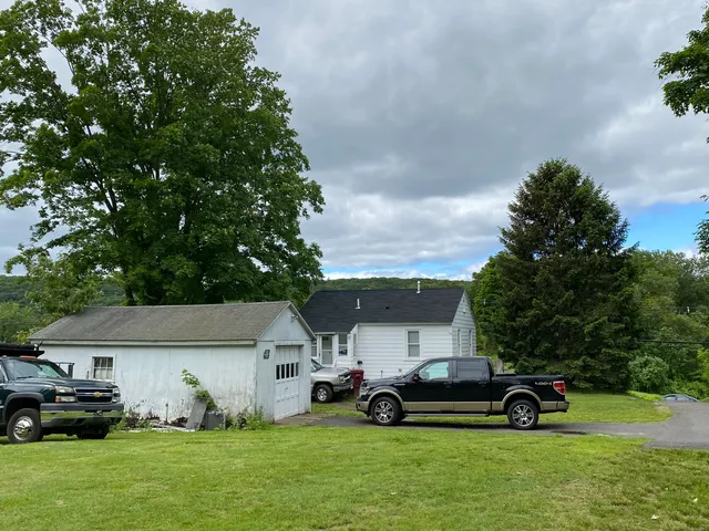 a car parked in front of a house with a yard