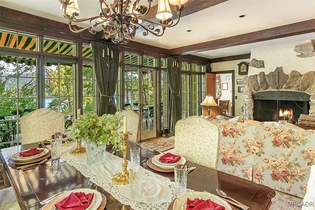 a dining room with furniture large windows and wooden floor