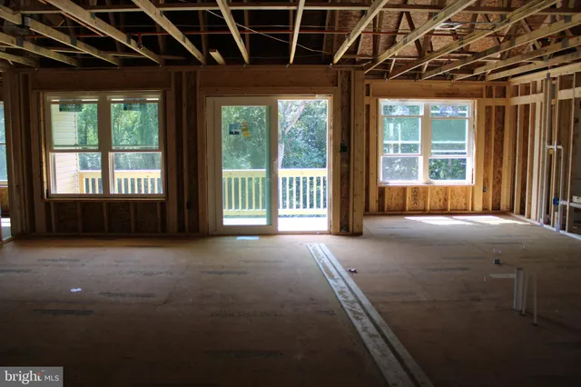 a view of an empty room with a fireplace and a window