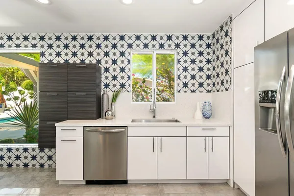 a kitchen with stainless steel appliances a stove a chimney a sink and a refrigerator