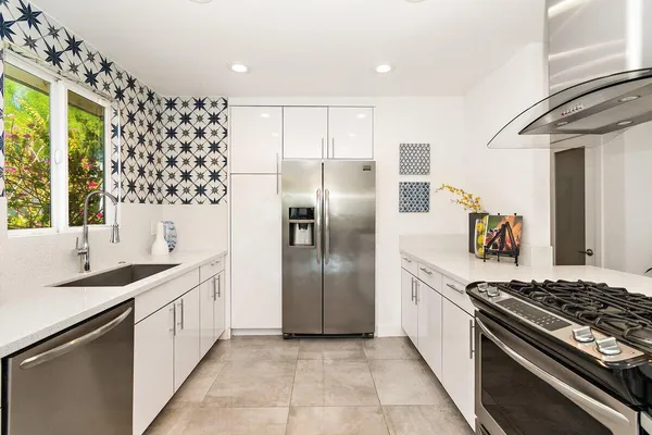 a kitchen with stainless steel appliances granite countertop a sink stove and refrigerator