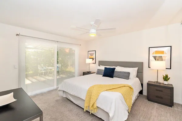 a spacious bedroom with a bed and a lamp next to a window