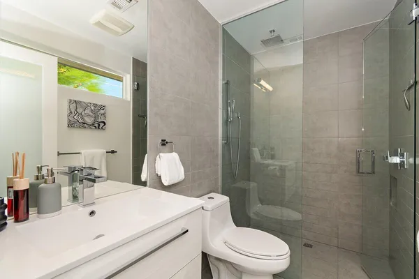 a bathroom with a sink a toilet and shower