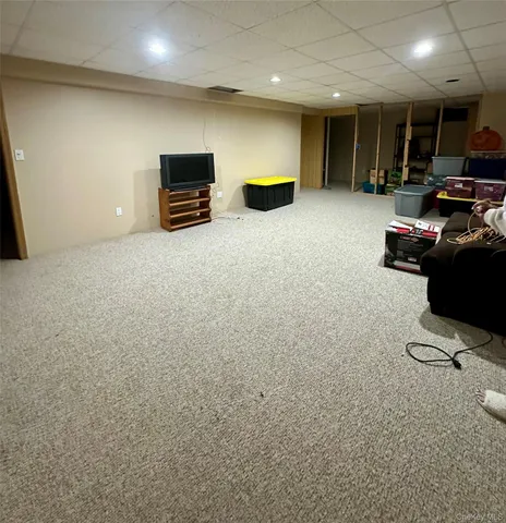 an empty room with furniture and a flat screen tv