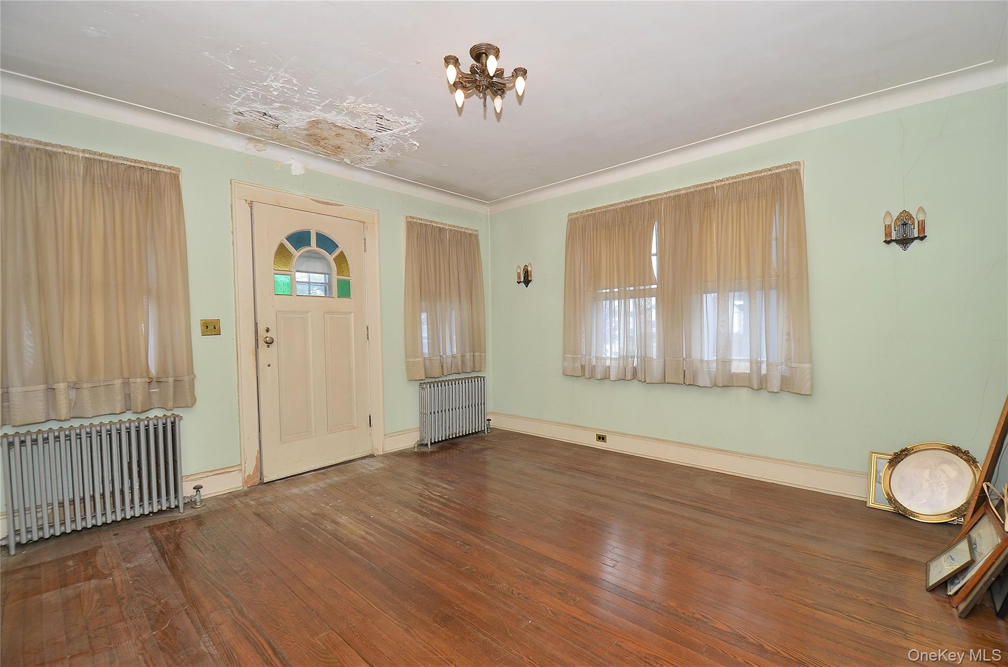 2586 Riverside Drive Wantagh, NY 11793 - Photo 7 of 28 Living Room featuring a solid wood door, hardwood flooring, and crown molding