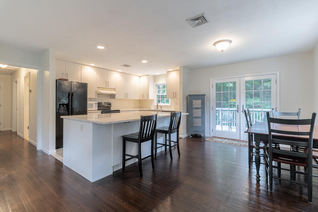 3 Hollow Spring Road Norwalk, CT 06854 - Photo 8 of 30 a kitchen with stainless steel appliances a dining table chairs refrigerator microwave and cabinets