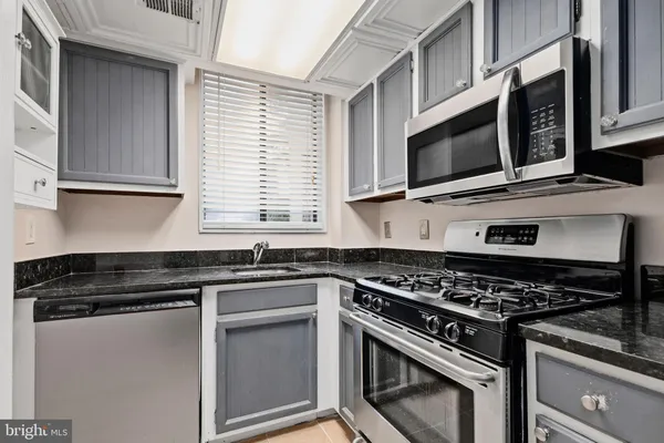 a kitchen with stainless steel appliances granite countertop a stove and a microwave