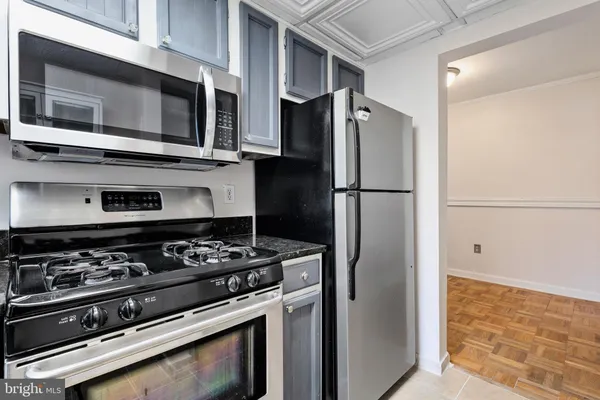 a kitchen with stainless steel appliances granite countertop a refrigerator and a stove top oven