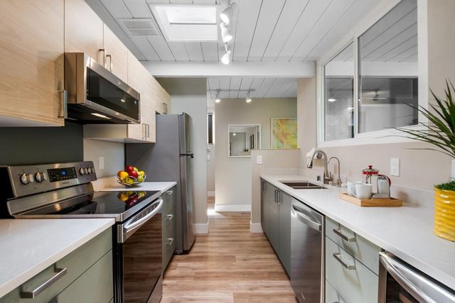 a kitchen with stainless steel appliances granite countertop a sink and a stove