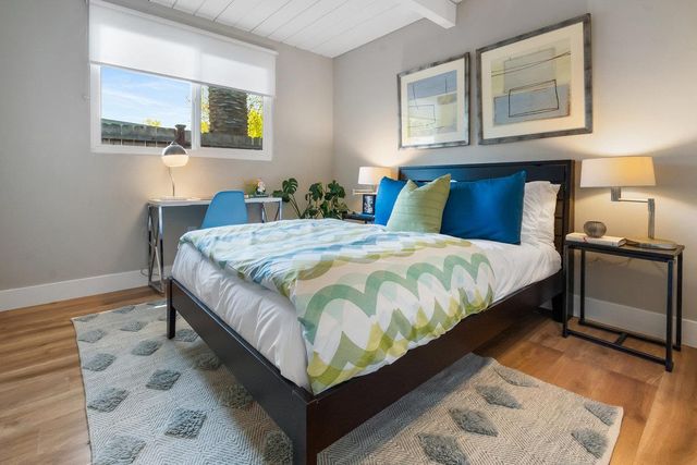 a large bed sitting in a bedroom next to a lamp with a chandelier