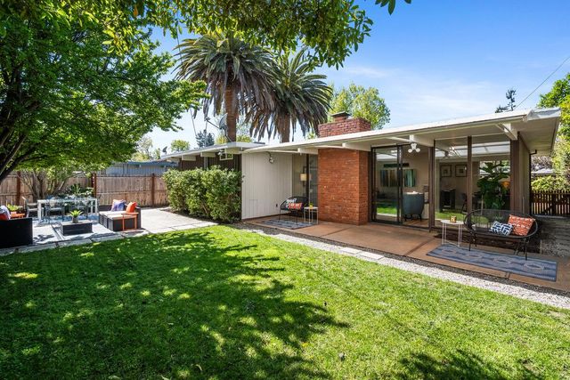 a view of a house with backyard sitting area and garden
