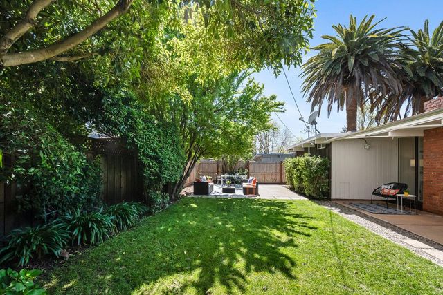 a view of a house with backyard and sitting area