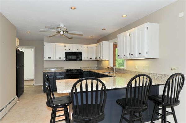 6 Bradish Farm Road Upton, MA 01568 - Photo 8 of 30 a kitchen with stainless steel appliances a table chairs and a refrigerator