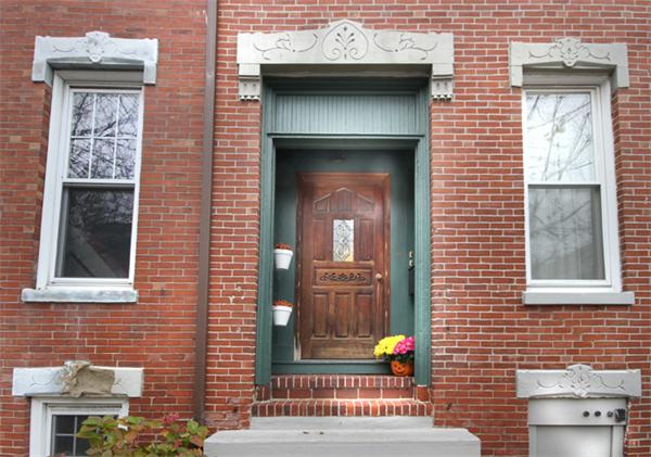 a view of brick house with a door and a window