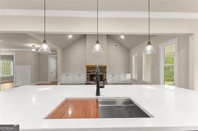 a view of a kitchen with kitchen island a chandelier and living room view