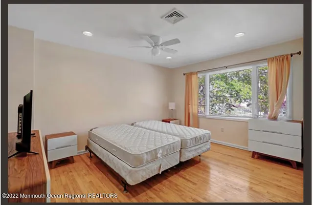 a bedroom with a bed and a wooden floor