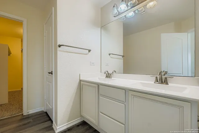 a bathroom with a double vanity sink and mirror