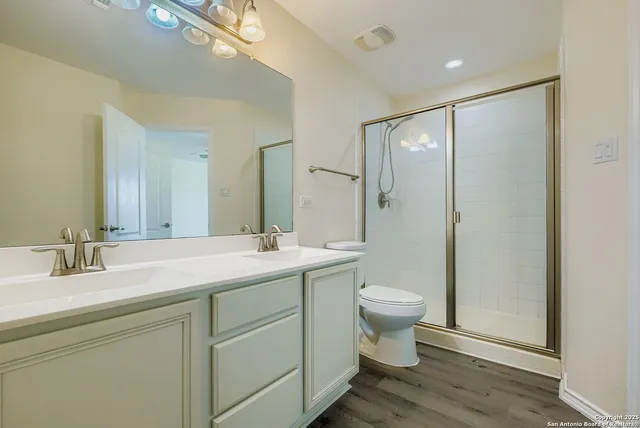 a bathroom with a double vanity sink toilet and a mirror