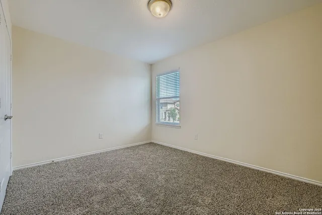 a view of an empty room with window and closet