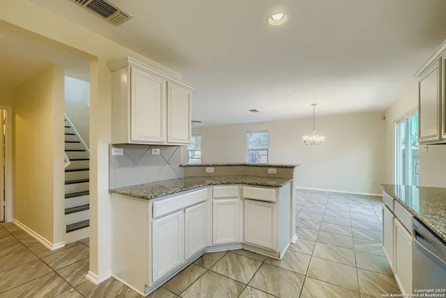a kitchen with granite countertop a sink and cabinets