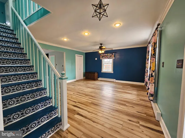 a view of a hallway with wooden floor and staircase
