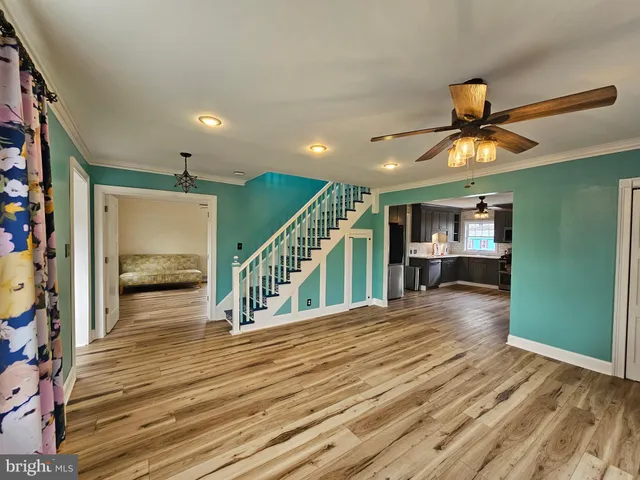 a view of a livingroom with a furniture stairs wooden floor and a chandelier