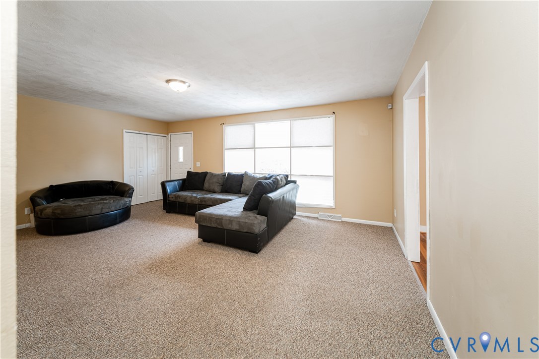 26746 Oxford Road Ruther Glen, VA 22546 - Photo 12 of 25 a living room with furniture a ceiling fan and a window